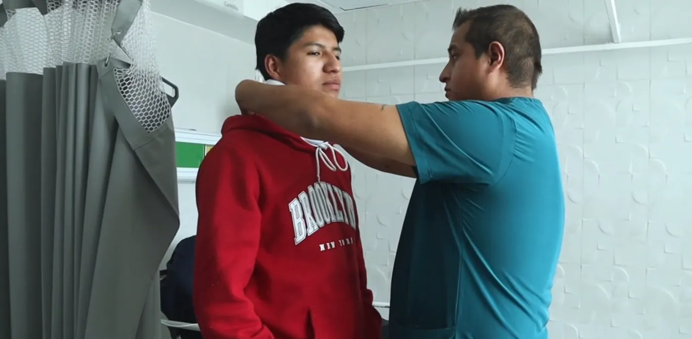 Médico de urgencias revisando a un paciente con collarín